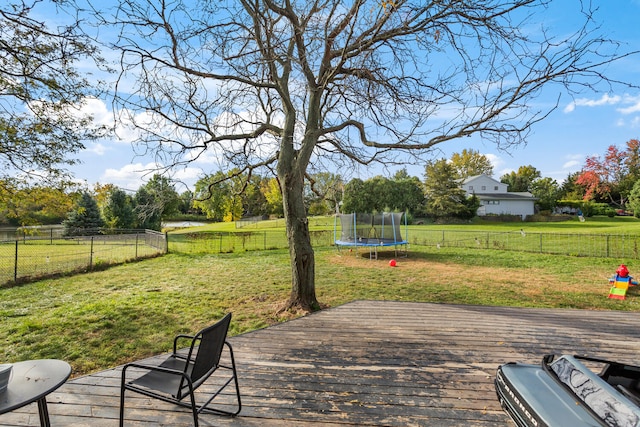 wooden terrace featuring a yard and a trampoline