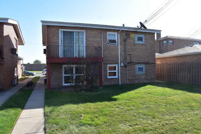 back of house with a balcony and a lawn