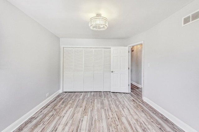 unfurnished bedroom with a closet and light hardwood / wood-style flooring