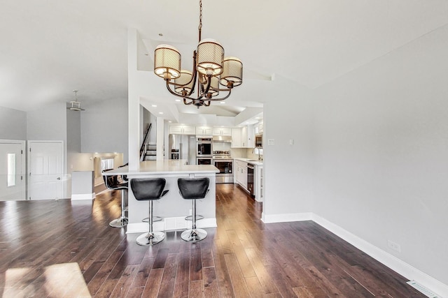 kitchen featuring dark wood-type flooring, stainless steel appliances, sink, white cabinetry, and high vaulted ceiling