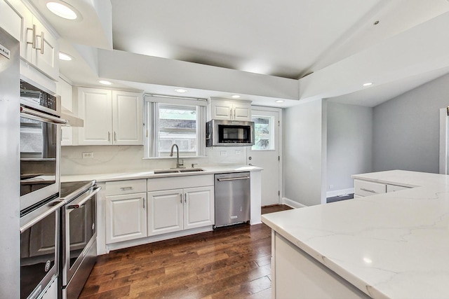 kitchen with appliances with stainless steel finishes, white cabinets, sink, and dark hardwood / wood-style floors