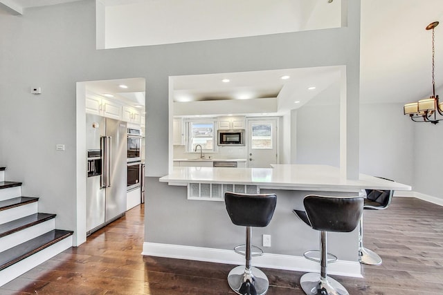 kitchen featuring white cabinetry, stainless steel appliances, and dark wood-type flooring