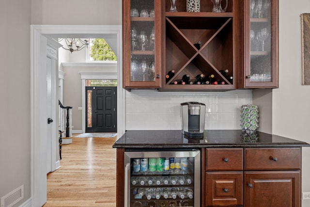 bar featuring beverage cooler, backsplash, and light hardwood / wood-style floors