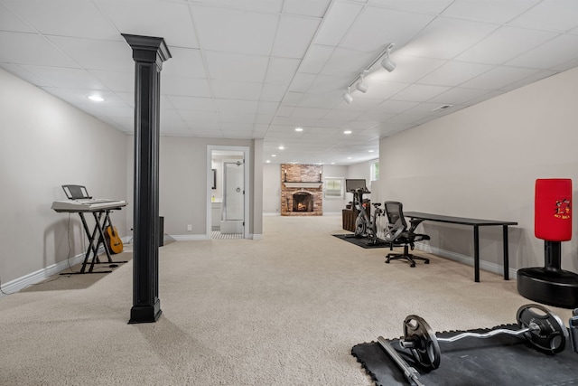 workout room with a fireplace, a drop ceiling, carpet, and track lighting