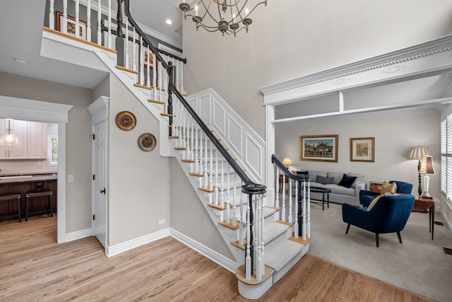 staircase featuring a chandelier, hardwood / wood-style floors, and a healthy amount of sunlight