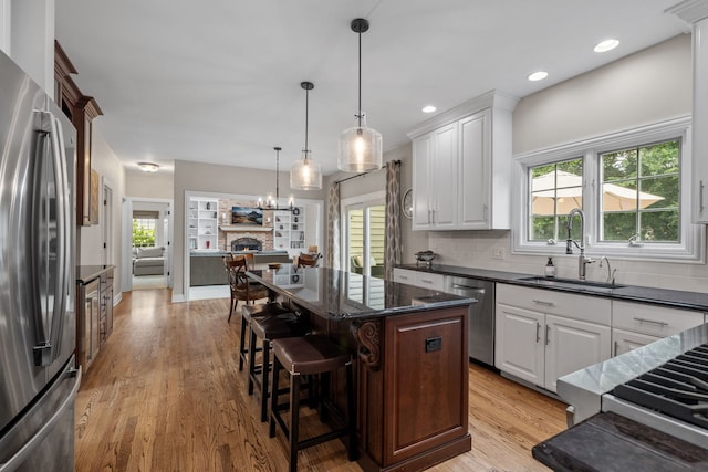 kitchen featuring light hardwood / wood-style flooring, a center island, stainless steel appliances, and white cabinets