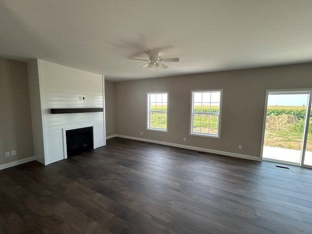 unfurnished living room featuring ceiling fan and dark hardwood / wood-style floors