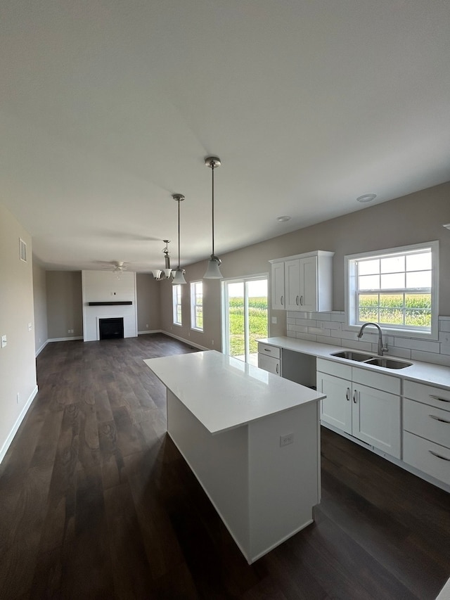 kitchen featuring a center island, white cabinetry, sink, and dark hardwood / wood-style floors