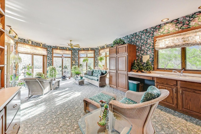 sunroom with ceiling fan, a healthy amount of sunlight, and sink