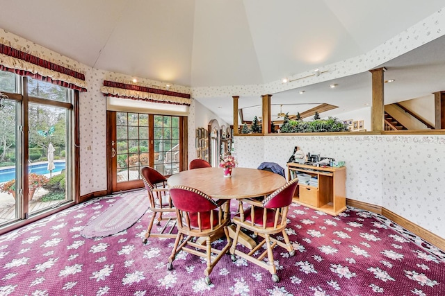 carpeted dining area with high vaulted ceiling