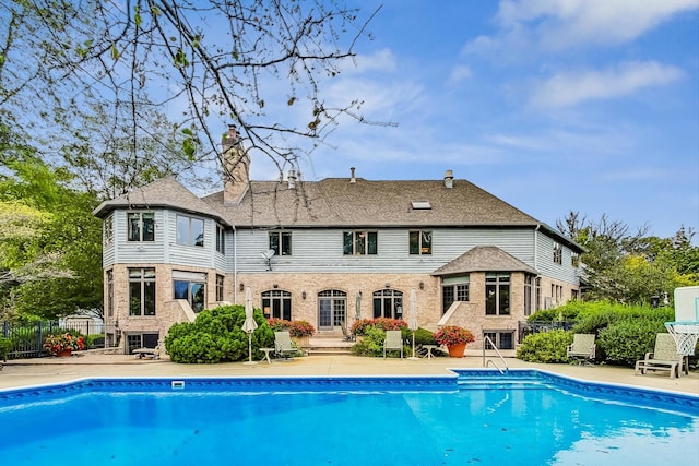 back of house with a patio and a fireplace