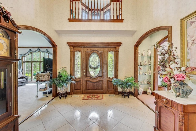 entrance foyer with light tile patterned flooring and a high ceiling