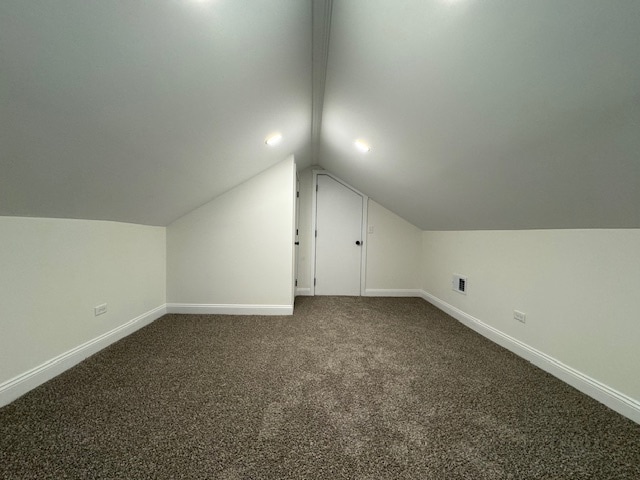 additional living space with vaulted ceiling and carpet