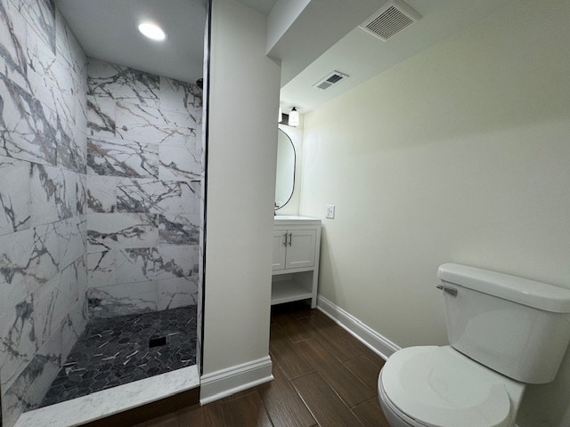 bathroom featuring walk in shower, hardwood / wood-style flooring, vanity, and toilet