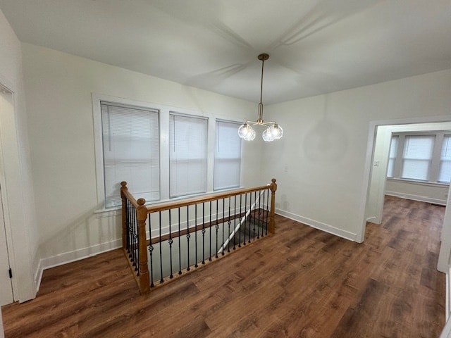 stairway with hardwood / wood-style flooring and a chandelier