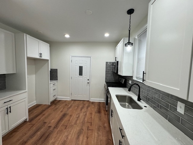 kitchen featuring white cabinets, sink, decorative light fixtures, stainless steel appliances, and dark hardwood / wood-style floors