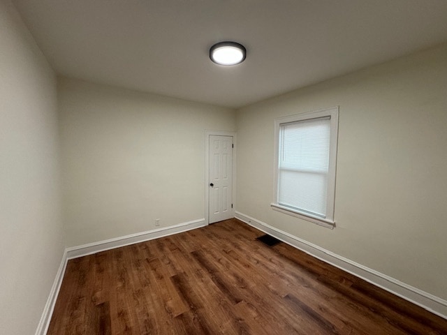 empty room with dark hardwood / wood-style flooring