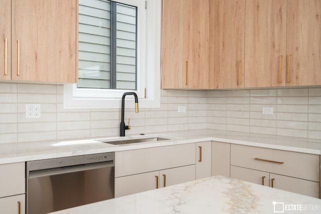 kitchen featuring light stone counters, dishwasher, sink, light brown cabinetry, and backsplash