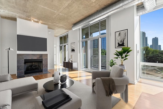 living room with a tile fireplace and light hardwood / wood-style flooring