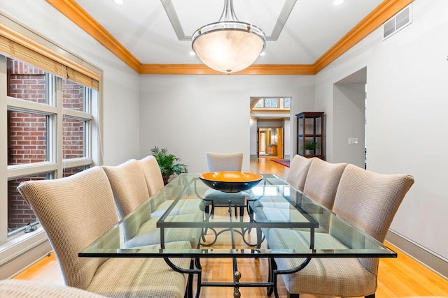 dining area with light hardwood / wood-style floors and crown molding