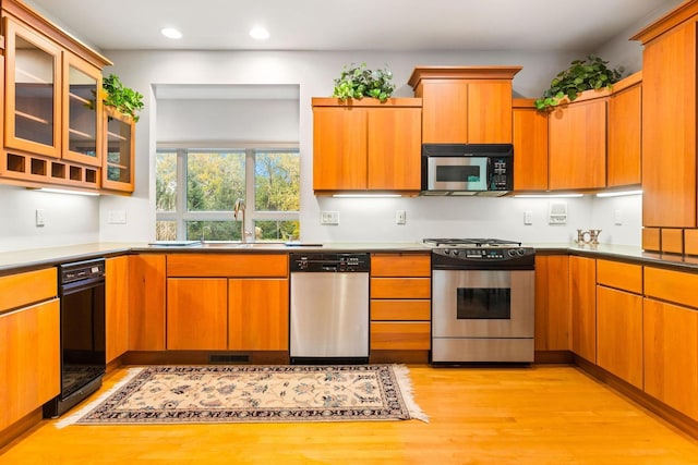 kitchen with sink, stainless steel appliances, and light hardwood / wood-style floors