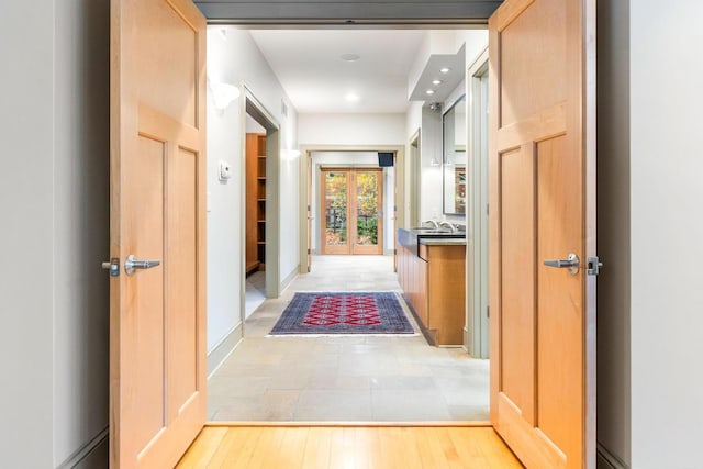 hall with light hardwood / wood-style floors and sink