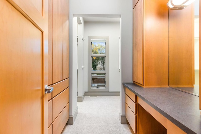 hall with light colored carpet