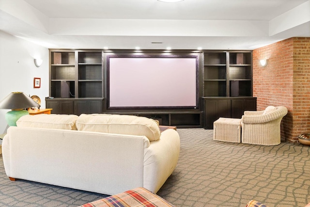 carpeted home theater room with brick wall