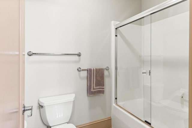 bathroom featuring combined bath / shower with glass door and toilet