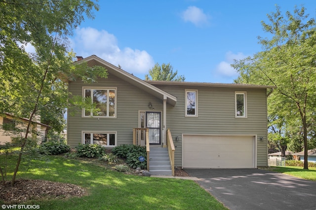 bi-level home featuring a garage and a front lawn