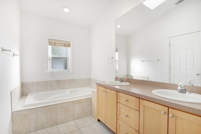 bathroom featuring tiled tub, tile patterned flooring, and vanity