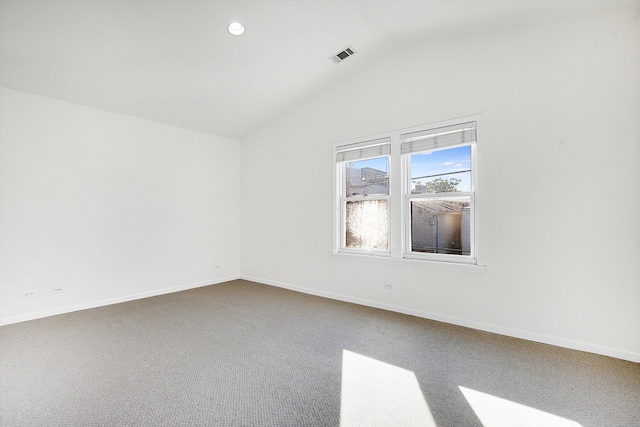 carpeted empty room with vaulted ceiling