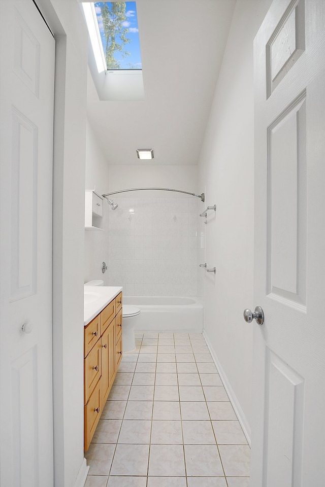 full bathroom featuring vanity, tiled shower / bath combo, tile patterned flooring, lofted ceiling with skylight, and toilet