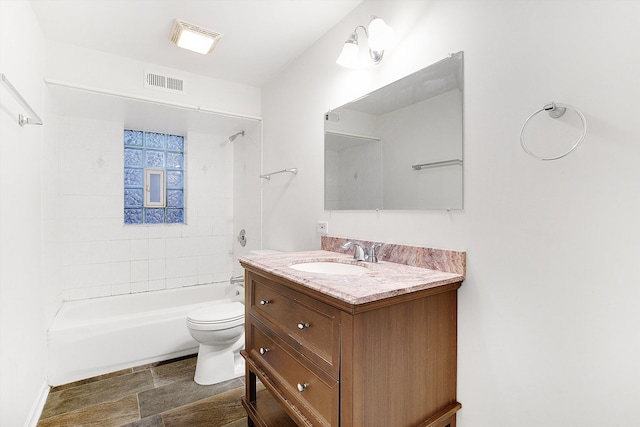 full bathroom featuring tiled shower / bath combo, vanity, and toilet