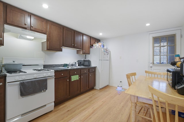 kitchen with dark brown cabinets, light wood-type flooring, sink, and white appliances