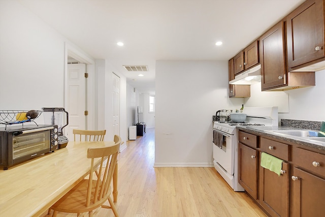 kitchen with sink, light wood-type flooring, and white gas stove