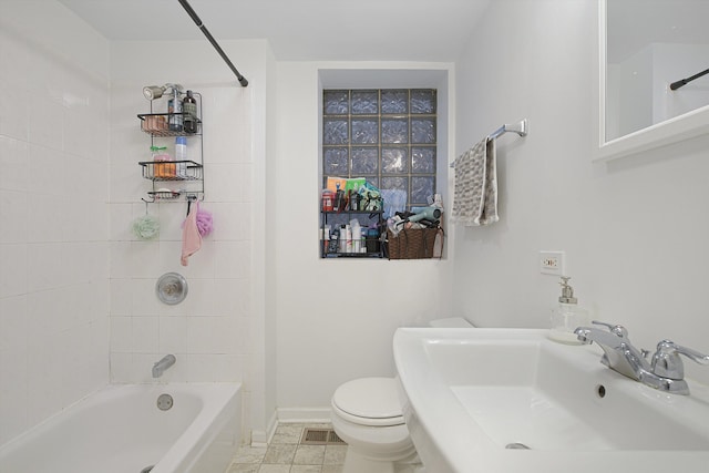 full bathroom with tile patterned flooring, tiled shower / bath, sink, and toilet