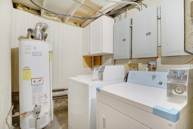 clothes washing area featuring cabinets, gas water heater, washer and dryer, and electric panel