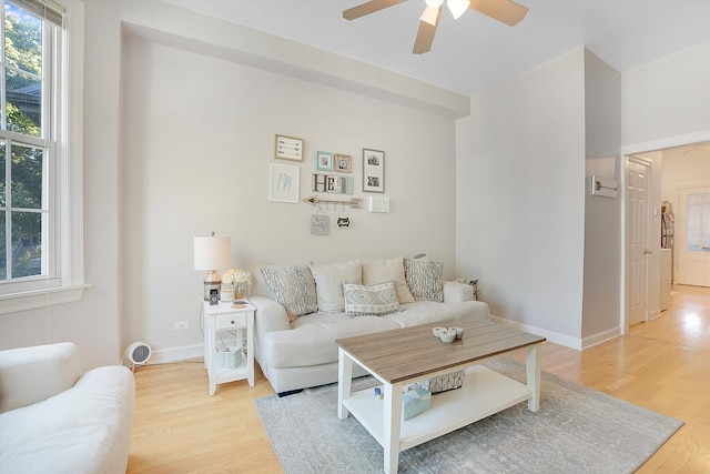 living room with ceiling fan and light hardwood / wood-style flooring