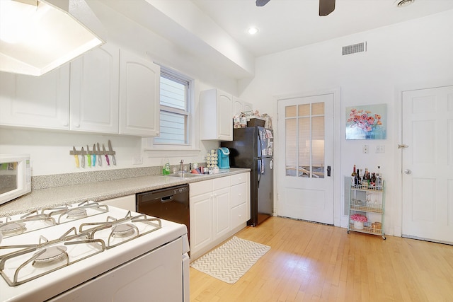 kitchen with white cabinets, black appliances, light hardwood / wood-style flooring, and sink