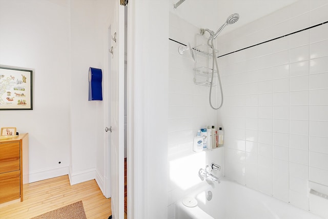 bathroom with tiled shower / bath combo and hardwood / wood-style floors