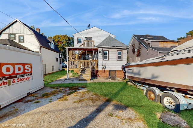 back of house featuring a yard and covered porch