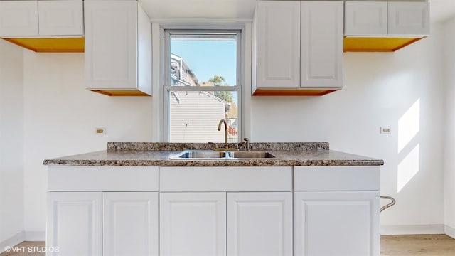 kitchen featuring sink, white cabinetry, and light hardwood / wood-style flooring