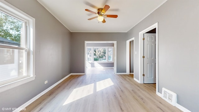 spare room with a healthy amount of sunlight, light wood-type flooring, and ceiling fan