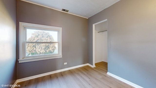 unfurnished room with a textured ceiling and light wood-type flooring