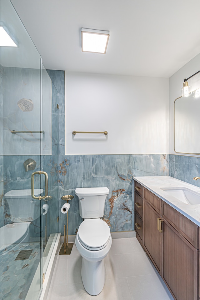 bathroom featuring tile walls, toilet, vanity, an enclosed shower, and tile patterned flooring