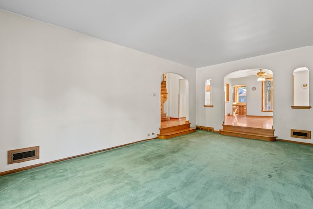 unfurnished living room featuring carpet floors and ceiling fan