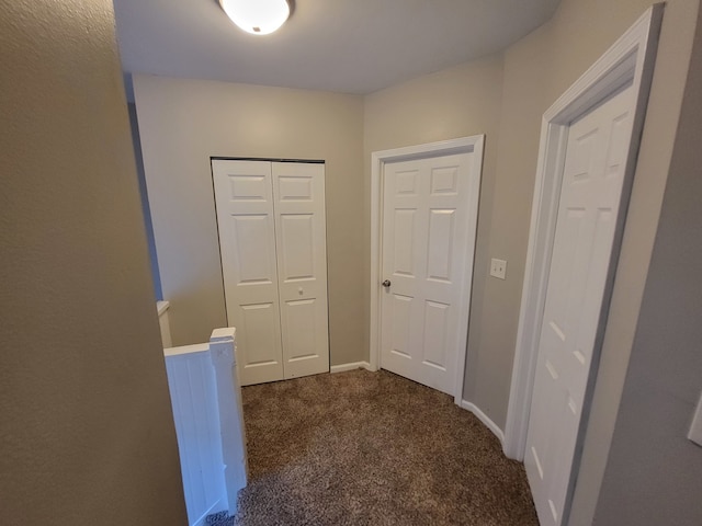 hallway with dark colored carpet and radiator