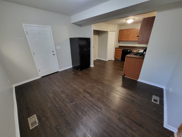 kitchen with black appliances and dark hardwood / wood-style flooring