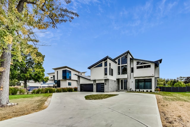 contemporary home featuring a garage and a front lawn